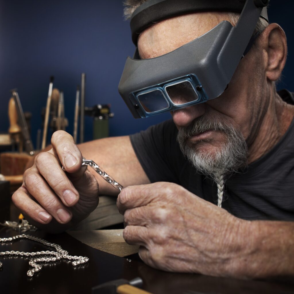 A goldsmith using Optivisor headband magnifiying glasses